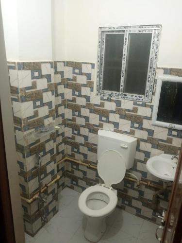 a bathroom with a toilet and a sink at The Pinnacle Stays in Guwahati