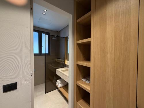 a walk in closet with wooden shelves in a bathroom at Riviera Boutique Hotel by Pomo d'oro in Vlorë