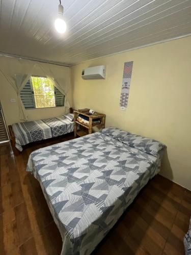a bedroom with a large bed in a room at Pousada Rural João De Barro 1 in Capela Ivapurunduva