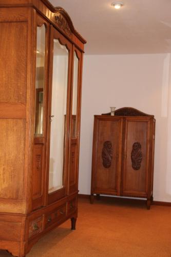 a wooden cabinet with a mirror and a cabinet at Die gute Stube in Wernigerode