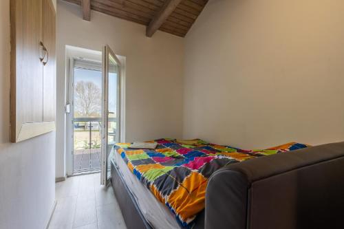 a bedroom with a bed with a colorful blanket at Zamárdi Parti Apartman in Zamárdi