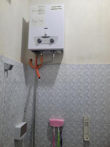 a scale on the wall of a bathroom with stools at The Sinta Bali in Munduk
