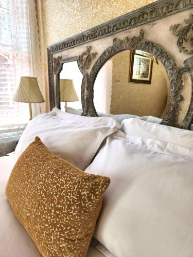 a bedroom with a large mirror above a bed at The Mason Cottage Downtown in Cape May