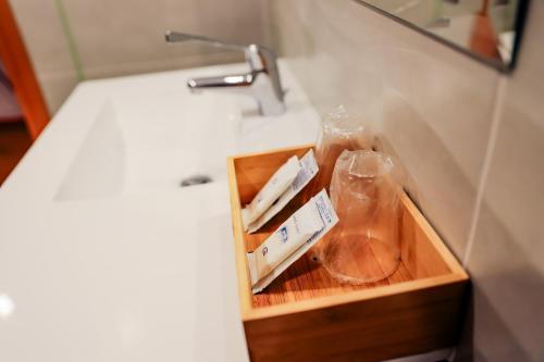 ein Badezimmerwaschbecken mit einer Holzschublade mit einem Waschbecken in der Unterkunft Hotel Flor do Minho in Valença