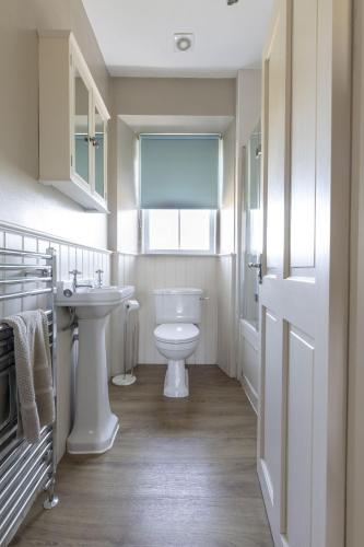 a bathroom with a white toilet and a sink at Fordel Cottage in Dalkeith