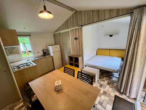 a small room with a bed and a table at Camping le Martin Pêcheur in Magné