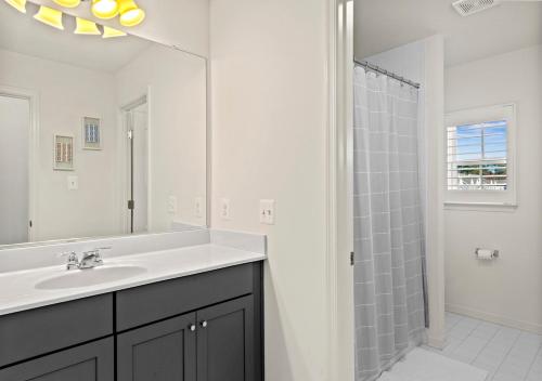 a white bathroom with a sink and a shower at Modern Townhouse with Pool Gym & Tennis Near Beach in Ocean View