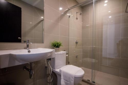 a bathroom with a toilet and a sink and a shower at Fuller Hotel Kulim in Kulim