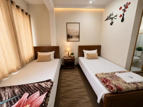 two beds in a small room with at Highlander inn Skardu in Skardu