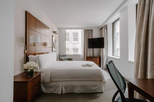 a hotel room with a bed and a television at Club Quarters Hotel Central Loop, Chicago in Chicago