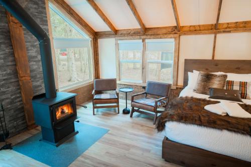 a bedroom with a bed and a wood stove at Sundance By Basecamp in Kananaskis Village