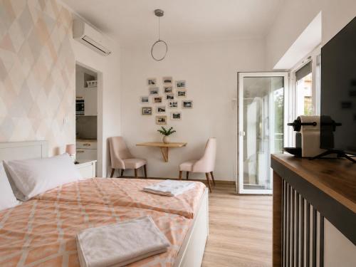 a bedroom with a bed and a table with chairs at Hilltop Apartments in Fonyód