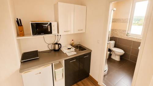 a small kitchen with a sink and a microwave at Hilltop Apartments in Fonyód