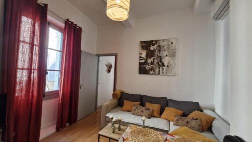 salon z kanapą i oknem w obiekcie Appartement w mieście Uzès