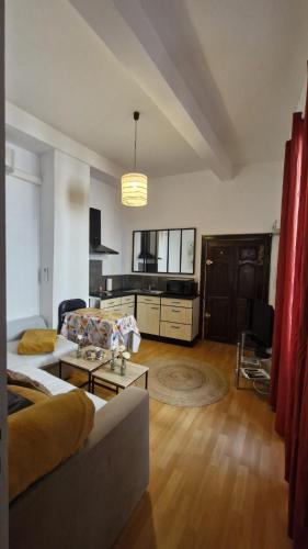 salon z kanapą i stołem w obiekcie Appartement w mieście Uzès
