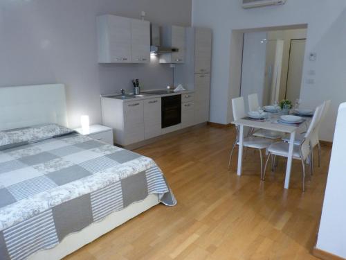 ボローニャにあるResidenza Piazza Santo Stefanoのベッドルーム1室(ベッド1台、テーブル、椅子付)
