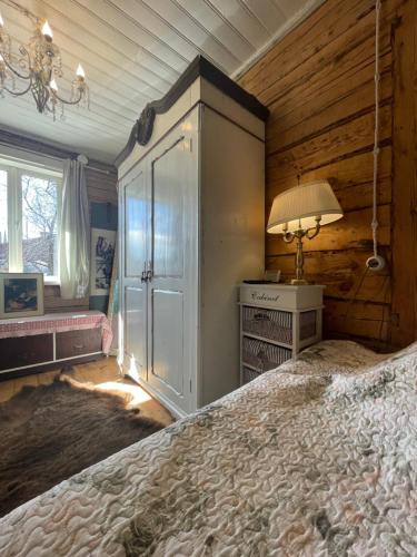 a bedroom with a large bed and a lamp at Posti Tiny House with Garden in Haapsalu