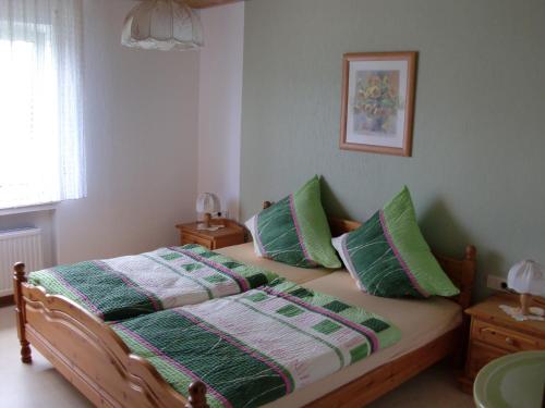 a bedroom with a bed with two green pillows at Ferienhaus Margaretha in Hallschlag