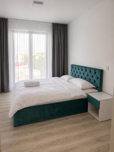 a bedroom with a large bed with a blue headboard at Nolia Apartments in Bucharest