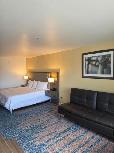 a hotel room with a bed and a couch at Omak Inn in Omak