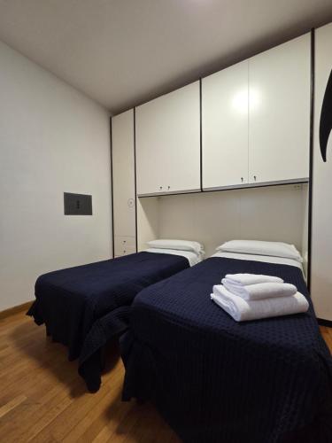 two beds in a room with white cabinets at Appartamento Polidea in Reggio di Calabria