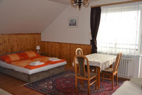 een slaapkamer met een bed en een tafel en stoelen bij Penzion Panorama in Beroun