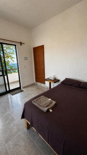 a bedroom with a bed and a sliding glass door at Casa Arena, Zipolite Playa del Amor in Zipolite
