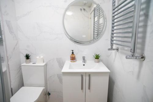 a white bathroom with a sink and a mirror at Hostale Blas Cabrera Madrid in Madrid