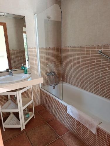a bathroom with a tub and a sink and a mirror at Cor De Prades in Mont-ral