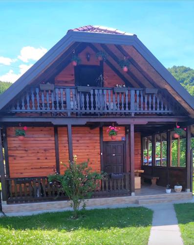 a log cabin with a porch and a balcony at Brvnara Sofiana in Bajina Bašta