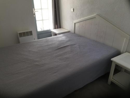 a white bed in a room with a window at Charmant Appartement - Bordaberry in Urrugne