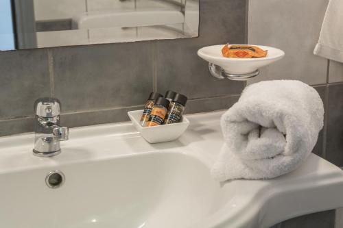 a white bathroom sink with a towel on it at MIRA Resort Maizonettes in Lefkada