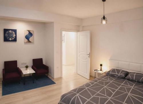 ein Schlafzimmer mit einem Bett, zwei Stühlen und einem Tisch in der Unterkunft Cavdarov in Štip