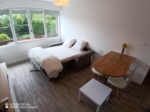 a small room with a bed and a table at Les Marines du Cachalot in Villers-sur-Mer