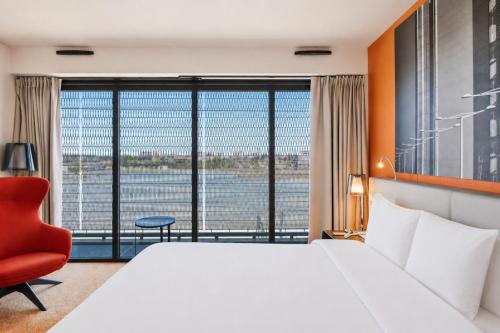 a hotel room with a large bed and a large window at Radisson Blu Hotel Bordeaux in Bordeaux