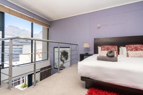 a bedroom with a bed and a large window at Skyline Living, Table Mountain Views in Cape Town