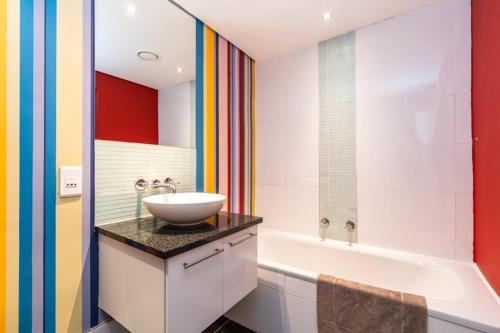 a bathroom with a sink and a bath tub at Skyline Living, Table Mountain Views in Cape Town