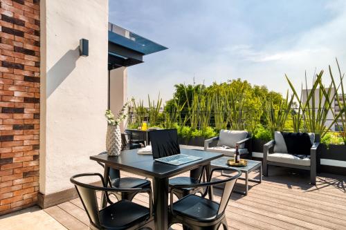 a patio with a table and chairs on a deck at ULIV Roma Norte in Mexico City