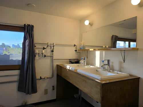 a bathroom with two sinks and a large mirror at Snow Nest Lodge in Sapporo