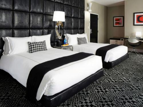 a hotel room with two beds and a leather wall at Hotel Clark in Los Angeles