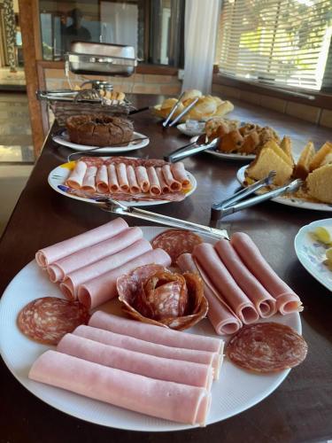 a table topped with plates of meats and pastries at Refúgio Alto do Pinhal in Santo Antônio do Pinhal