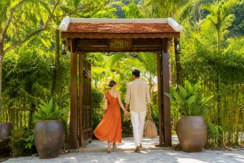 a man and a woman walking through a gate at Aman Retreat Ninh Binh in Ninh Binh