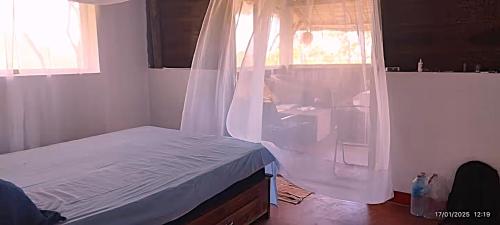 a bedroom with a bed with a mosquito net at Caban Zenfants in Sainte Marie