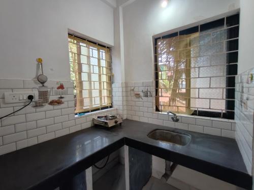 a bathroom with a sink and a window at The Long Stay Goa in Arambol