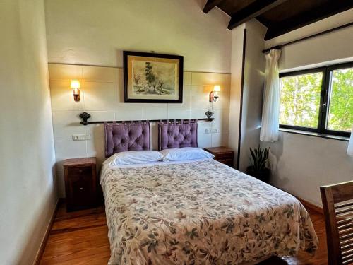 a bedroom with a bed with a purple head board at Amaicha Casona in Ribadesella