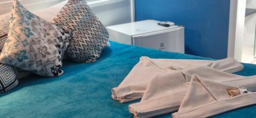 a blue bed with pillows and towels on it at Pousada Praia Brava in Matinhos