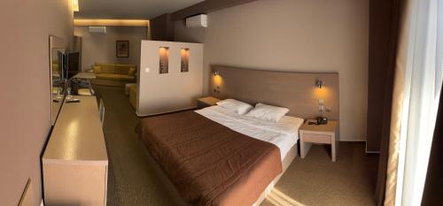 a small bedroom with a bed and a desk at Achillio Hotel in Komotini