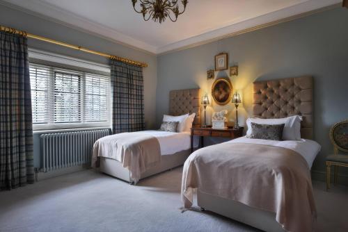 a bedroom with two beds and a window at Morland Manor in Peterborough