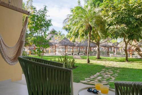 a patio with a table and chairs with a view of a park at Iberostar Selection Playa Mita - All Inclusive in Punta Mita