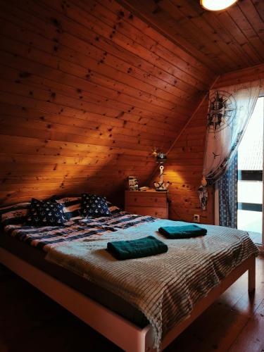 a bedroom with a bed in a wooden cabin at u HELanki - Domki letniskowe przy samej plaży - Kuźnica in Kuźnica